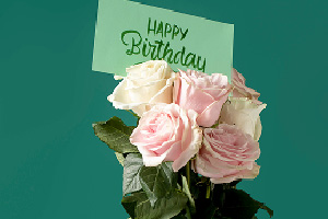 Bouquet Joyeux instant fleuri composé de roses blanches et roses avec une carte d’anniversaire.