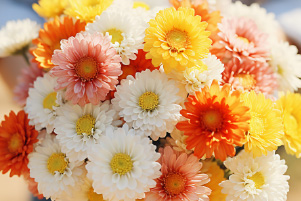 Bouquet Premier souffle avec fleurs pastel blanches, jaunes et orange