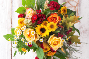 Bouquet douceur composé de fleurs de saison colorées, avec roses, tournesols et fleurs fraîches
