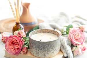 Bougie Douce lueur accompagnée de roses délicates dans une ambiance cocooning aux tons doux et apaisants