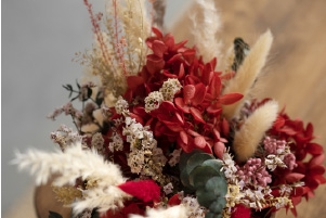 Bouquet Éclat intemporel composé de fleurs séchées rouges, graminées naturelles et feuillage délicat