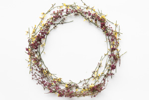Couronne naturelle composée de fleurs séchées champêtres aux teintes rose et jaune dans un esprit délicat et naturelle